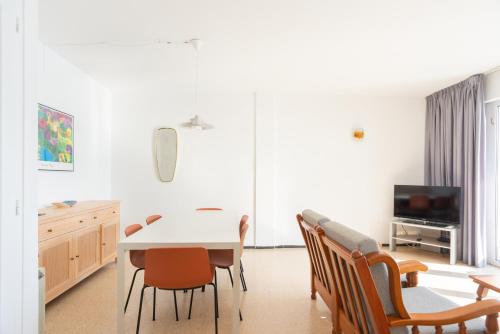 a dining room with a white table and chairs at Apartamentos Blanes-Condal Costa Brava in Blanes