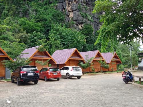 a group of cars parked in front of wooden buildings at Rammang-Rammang Cottage in Kasijala