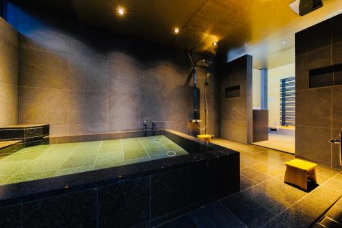 Hakuba Amber Resort by Jade Group في هاكوبا: حمام كبير مع حوض استحمام مع دش