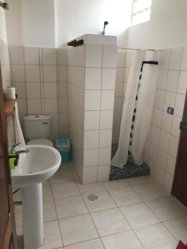 a bathroom with a sink and a shower and a toilet at Maio Relax in Vila do Porto