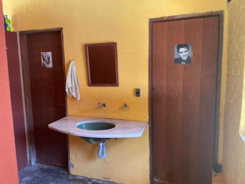 un baño con lavabo y una foto de un hombre en Sítio Ipecamirim, en Bragança Paulista