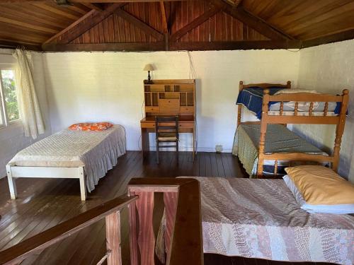 a room with two bunk beds and a desk at Sítio Ipecamirim in Bragança Paulista