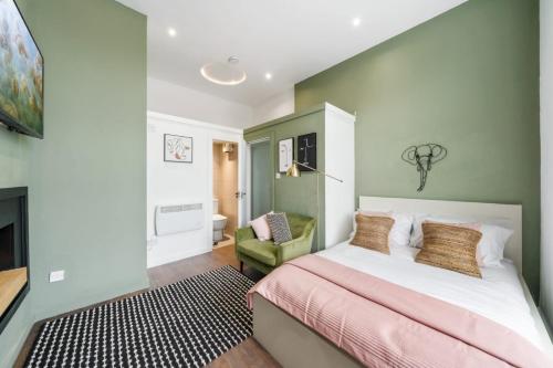 a bedroom with a bed and a green wall at Stunning studio flats in Penge in Sydenham