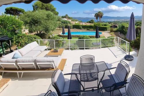 a patio with a couch and chairs and a pool at LE CLOS BUCCI - Golfe de Saint-Tropez - Les hauts de Grimaud, villa avec vue exceptionnelle in Grimaud