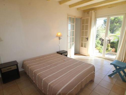 a bedroom with a bed and a large window at LE CLOS BUCCI - Golfe de Saint-Tropez - Les hauts de Grimaud, villa avec vue exceptionnelle in Grimaud