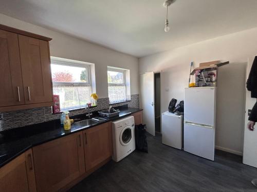 a kitchen with a white refrigerator and a washing machine at Glo Stay @ Hibbert Crescent in Skegby