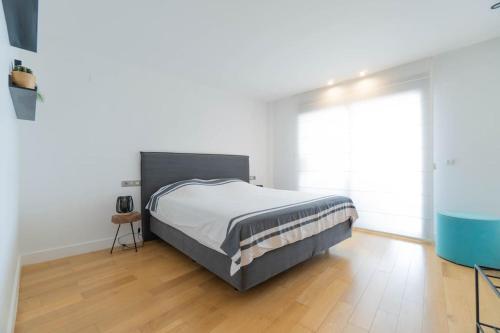 a bedroom with a bed and a wooden floor at Mascarat Beach Apartment de Lux, EN52B in Altea la Vieja