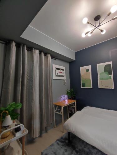 1 dormitorio con cama y pared azul en RC Staycation en Manila