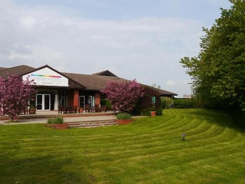 a house with a large lawn in front of it at Urban Hotel in Grantham