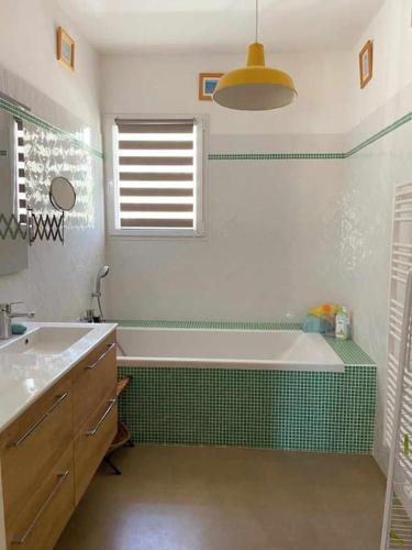 a bathroom with a bath tub and a sink at Emplacement idéal dans le Var ! in Cuers