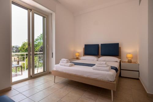 a bedroom with a bed and a large window at Nautika Suites in Alghero