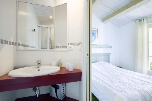 ein Bad mit einem Waschbecken und einem Bett in der Unterkunft LATITUDE46 maison de charme à Sainte Marie de Ré in La Noue