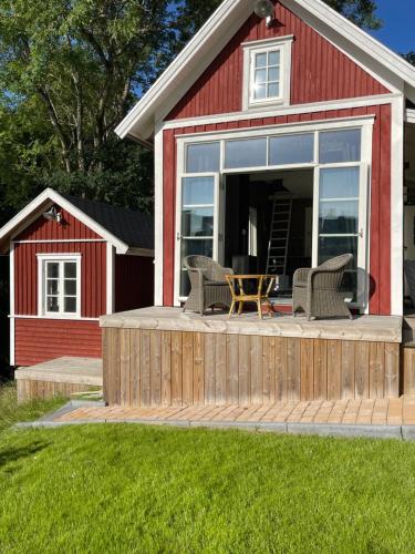 a deck with chairs and a table in a red barn at Forest house in Ljungskile