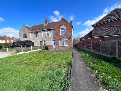 a house with a fence and a grass yard at Glo Stay @ Hibbert Crescent in Skegby