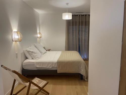 une chambre avec un lit, une chaise et une fenêtre dans l'établissement La Calanca - Appartement d'hôtes Centre ville de Sète parking gratuit, à Sète