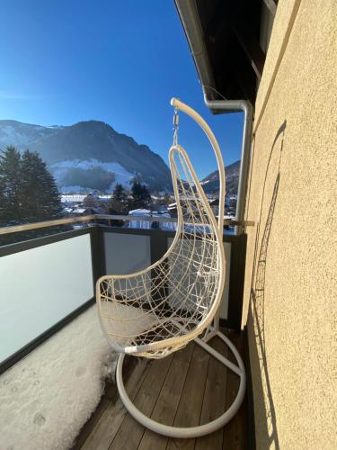 a rattan chair sitting on a balcony at Loft im Turm in Maishofen