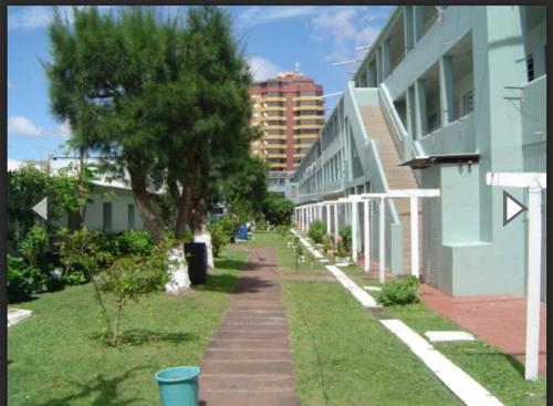 a sidewalk next to a building with trees and buildings at Apartamento vista pro mar in Tramandaí