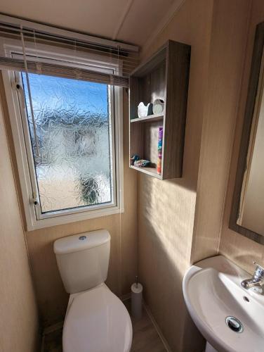 Baño pequeño con aseo y lavamanos en Relaxing Holiday Home Chickerell View Littlesea Haven, en Weymouth