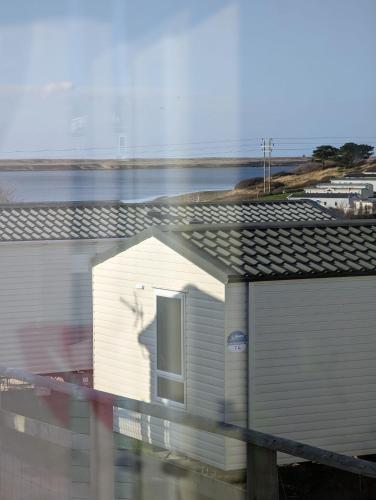 a white building with a window on top of it at Relaxing Holiday Home Chickerell View Littlesea Haven in Weymouth