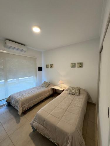 1 dormitorio con 2 camas y ventana en Casa de playa en Balneario Claromecó