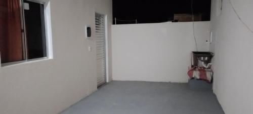 um quarto vazio com uma porta branca e uma janela em Lugar de paz em Marataízes