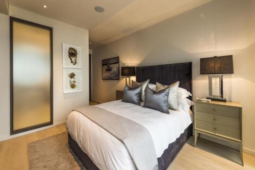 um quarto com uma grande cama branca e uma mesa de cabeceira em Subpenthouse sleeps 6, Stunning views of Tower Bridge! em Londres