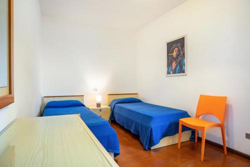 Pokój z 2 łóżkami, stołem i krzesłem w obiekcie Garden alle barche - Angela 3 w mieście Calceranica al Lago