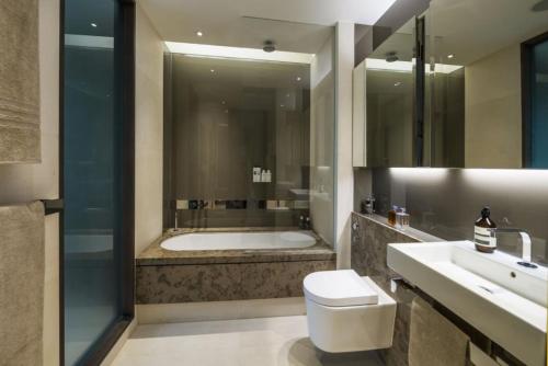 uma casa de banho com uma banheira, um WC e um lavatório. em Subpenthouse sleeps 6, Stunning views of Tower Bridge! em Londres