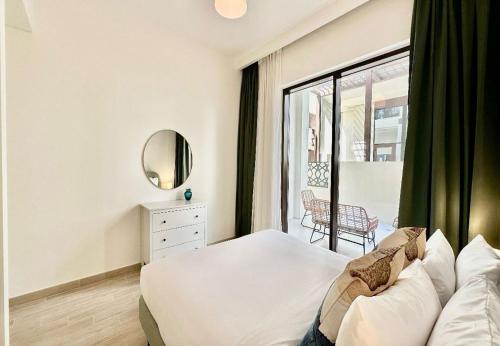 EasyGo - Sunset Creek 1 Bedroom في دبي: غرفة نوم بسرير ومرآة