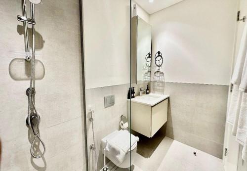 a bathroom with a shower and a toilet and a sink at EasyGo - Sunset Creek 1 Bedroom in Dubai