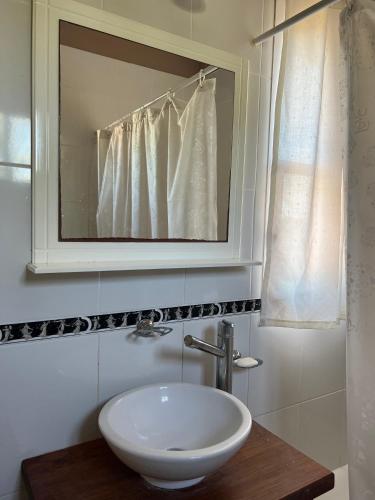 La salle de bains est pourvue d'un lavabo blanc et d'un miroir. dans l'établissement Departamento para 2 personas, à San Miguel del Monte