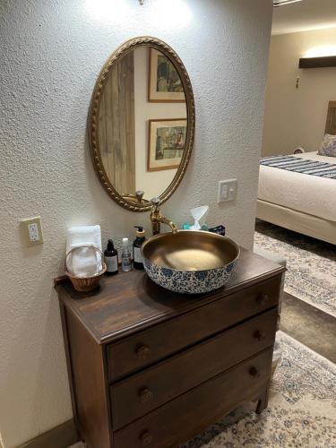 a bathroom with a sink and a mirror on a dresser at Prairie Rose Inn in WaKeeney