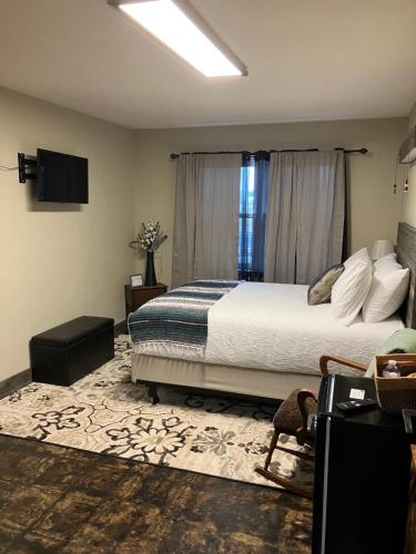 a bedroom with a bed and a television in it at Prairie Rose Inn in WaKeeney