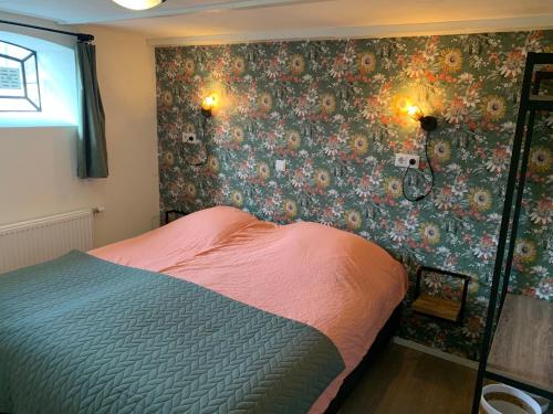 1 dormitorio con 1 cama y papel pintado con motivos florales en Logeerboerderij de Salix, en Hitzum