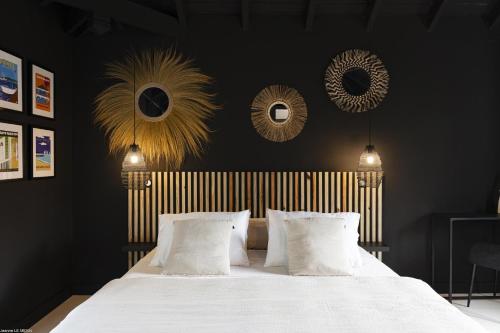 Un dormitorio con una cama blanca con paredes y espejos negros en Pomme Cannelle Luxury Suites & Spa, en Saint Martin