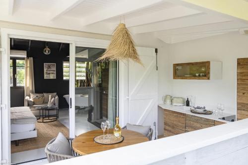 a kitchen and living room with a table and chairs at Pomme Cannelle Luxury Suites & Spa in Orient Bay
