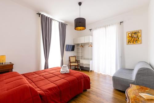 sypialnia z czerwonym łóżkiem i krzesłem w obiekcie Barrio 133 - double bedroom in center by Napoliapartments w mieście Neapol