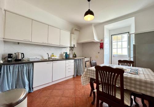 a kitchen with white cabinets and a table with a table cloth at Portuguese village apartment - Casa Martins No.54 in Freiria