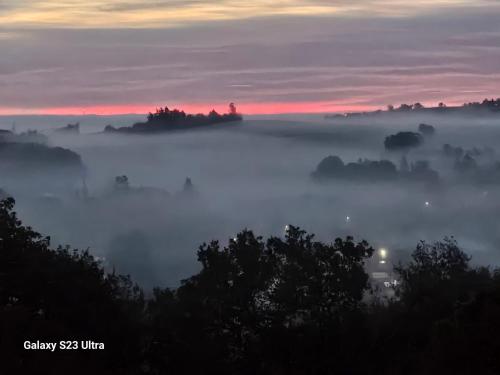 a foggy sunrise with the sun rising in the background at Belvédère du midi in Ayguesvives