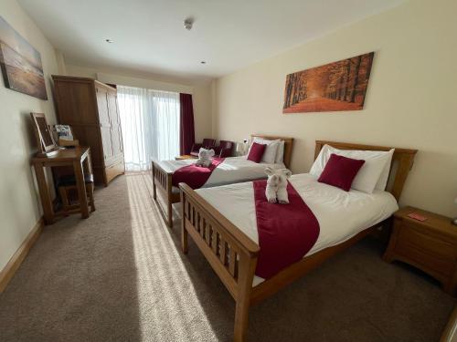 two beds in a hotel room with at Riverside Park & Country Club in South Molton