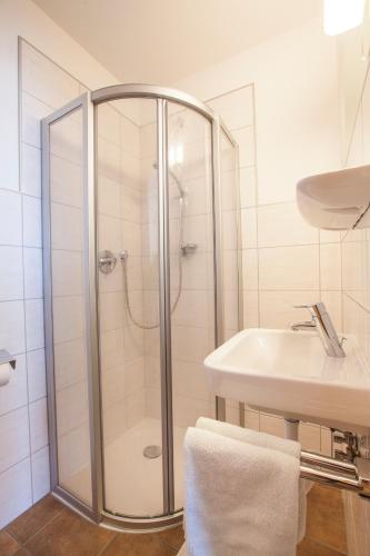 a white bathroom with a shower and a sink at Conny's Apartments in Neustift im Stubaital