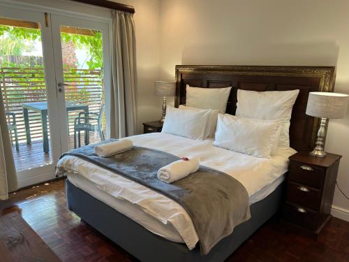 a bedroom with a large bed with two towels on it at Goblin's Mead in Edgemead