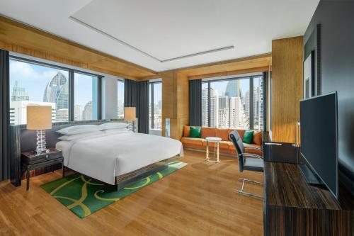 a bedroom with a bed and a living room at Renaissance Bangkok Ratchaprasong Hotel in Bangkok