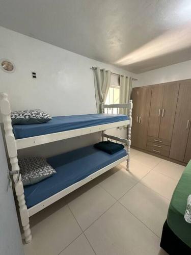 een slaapkamer met 2 stapelbedden met blauwe lakens bij Casa02 - Mariscal/Canto Grande a 150mts da praia in Bombinhas