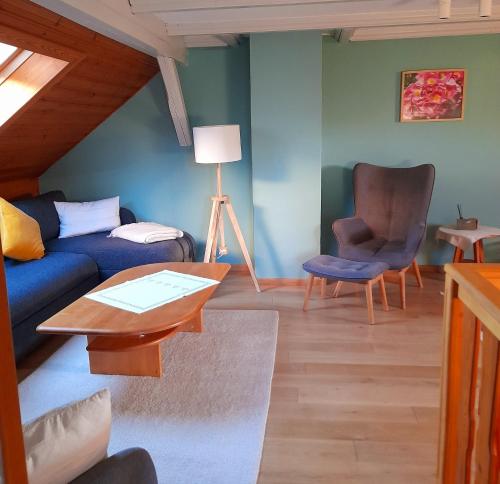 - un salon avec un canapé bleu et une chaise dans l'établissement Bauernhof Wagner, à Eisenach