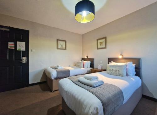 a hotel room with two beds and a blue light at West Highland Hotel in Mallaig