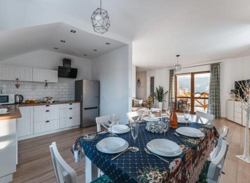 a kitchen and dining room with a table and chairs at Apartamenty ''Chcę Tu Zostać'' in Szczawnica