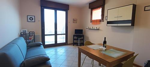 a living room with a blue couch and a table at Appartamento Gold Calcara in Calcara