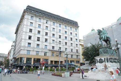 a large white building with a statue in front of it at Boutique Rooms in Belgrade