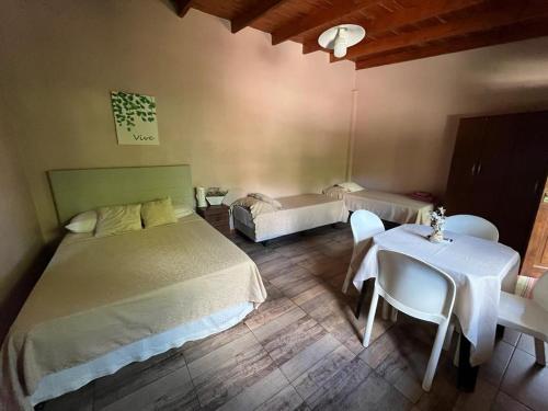 a bedroom with two beds and a table and chairs at LA SELVA MONOAMBIENTES in Puerto Iguazú